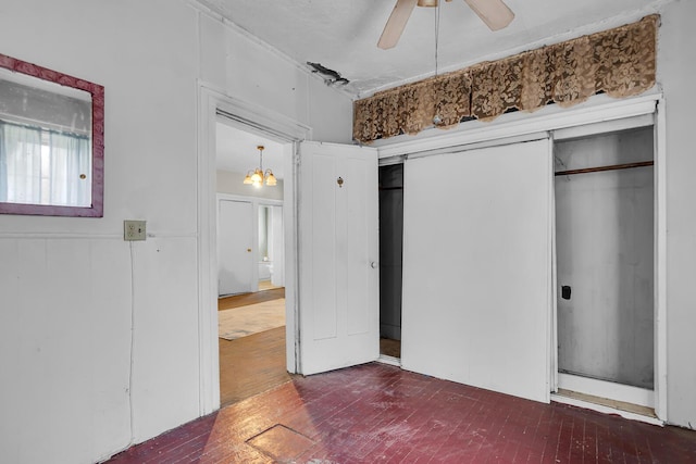 unfurnished bedroom featuring brick floor, a closet, ceiling fan, and ensuite bath