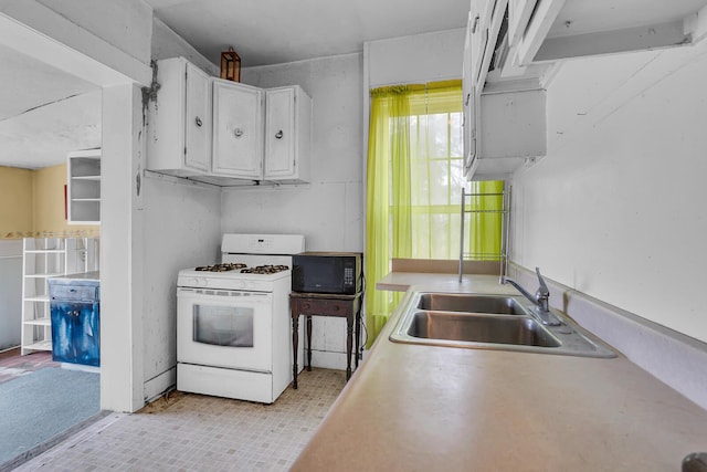 kitchen with black microwave, a sink, white cabinetry, white range with gas cooktop, and light countertops