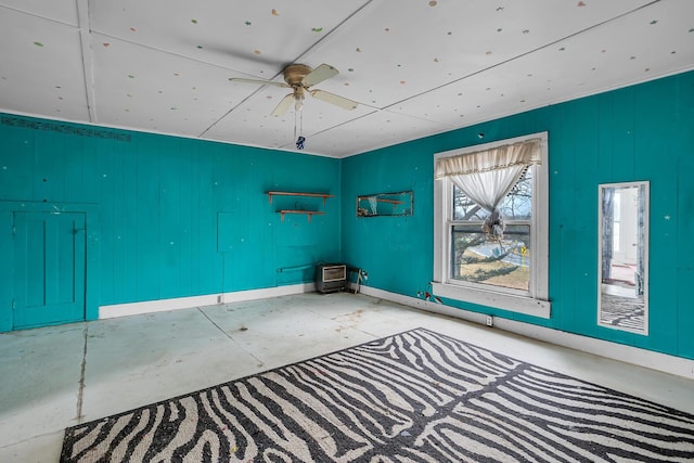 spare room featuring a ceiling fan and baseboards