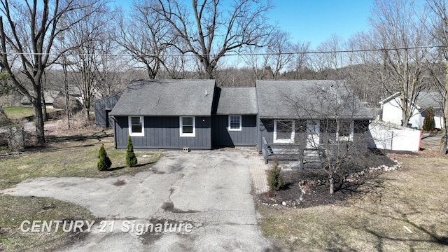 view of front of property featuring a shingled roof and asphalt driveway