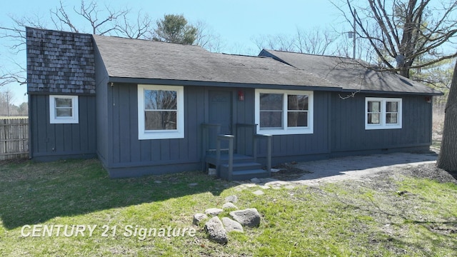 view of front of home with a front lawn and a shingled roof