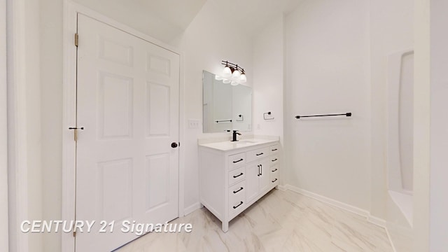 bathroom featuring baseboards, vanity, and marble finish flooring
