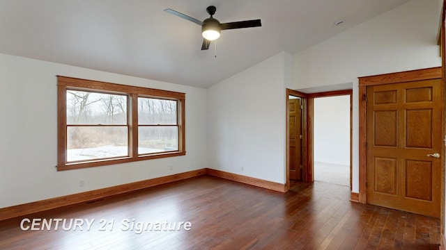 empty room with vaulted ceiling, dark wood-style floors, ceiling fan, and baseboards