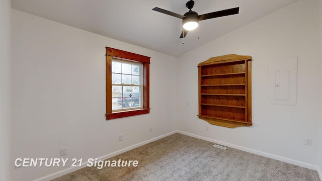 unfurnished room featuring carpet, baseboards, a ceiling fan, electric panel, and vaulted ceiling