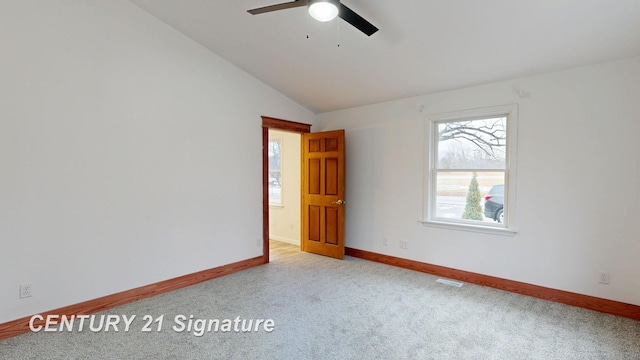 spare room with carpet, baseboards, ceiling fan, and vaulted ceiling