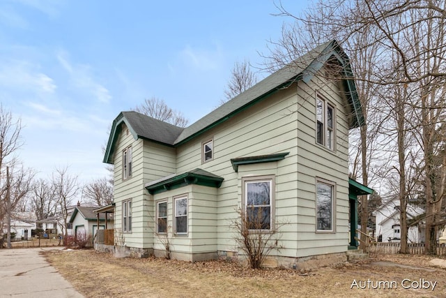 view of side of home with a shingled roof