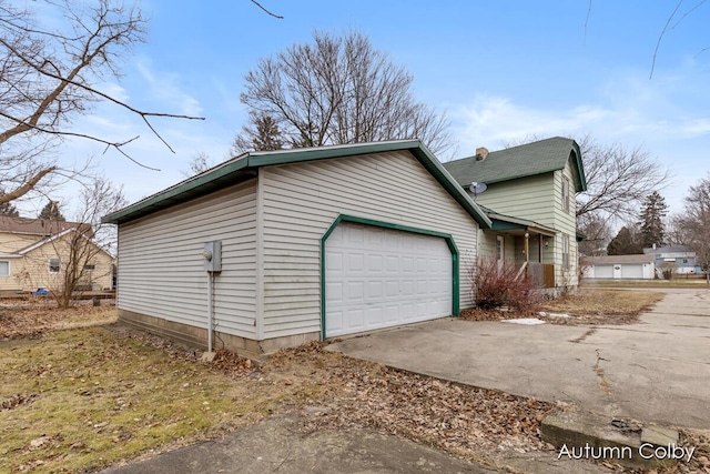 view of property exterior featuring a garage and concrete driveway