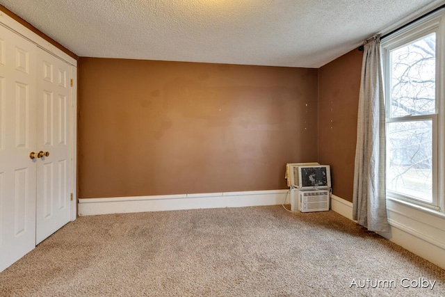 interior space with a textured ceiling and a wall mounted AC