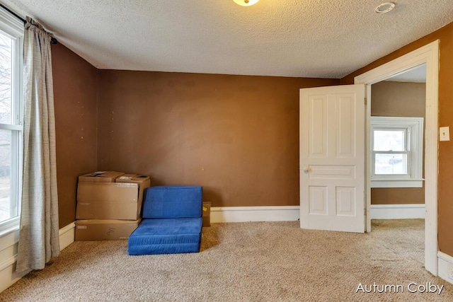 unfurnished room featuring carpet flooring, a textured ceiling, and baseboards