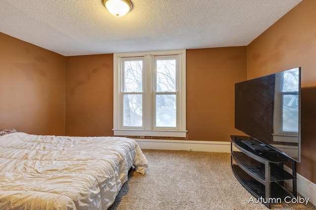 carpeted bedroom featuring baseboards and a textured ceiling