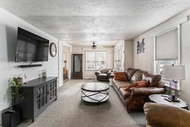 living area with a textured ceiling, a ceiling fan, carpet flooring, and a textured wall