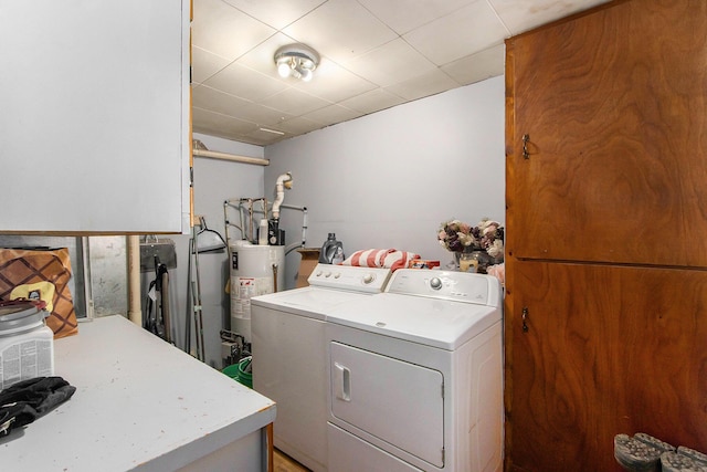 clothes washing area with water heater, laundry area, and washer and clothes dryer