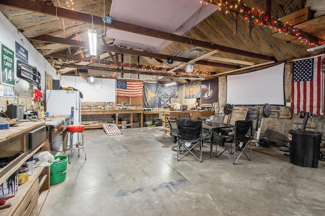 interior space featuring a workshop area and freestanding refrigerator