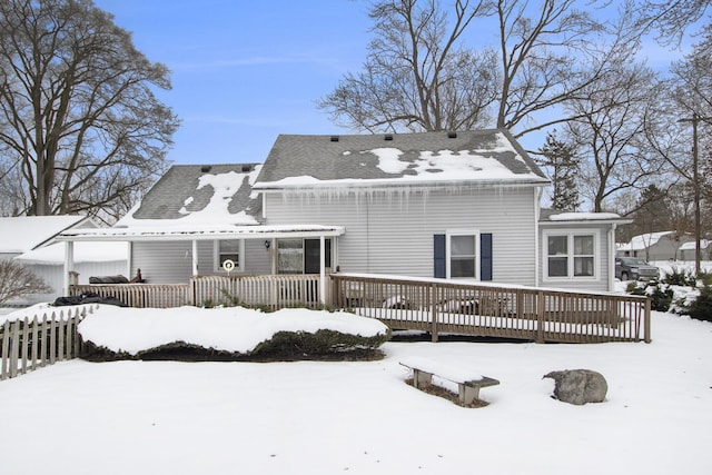 snow covered rear of property featuring a deck