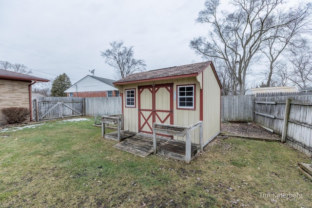 view of shed with a fenced backyard and a gate