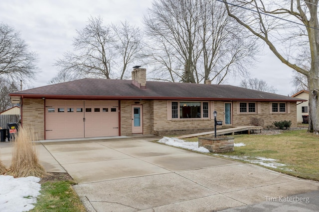 ranch-style house with brick siding, a chimney, an attached garage, a front yard, and driveway