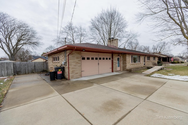 view of front of home with driveway, a chimney, an attached garage, fence, and brick siding