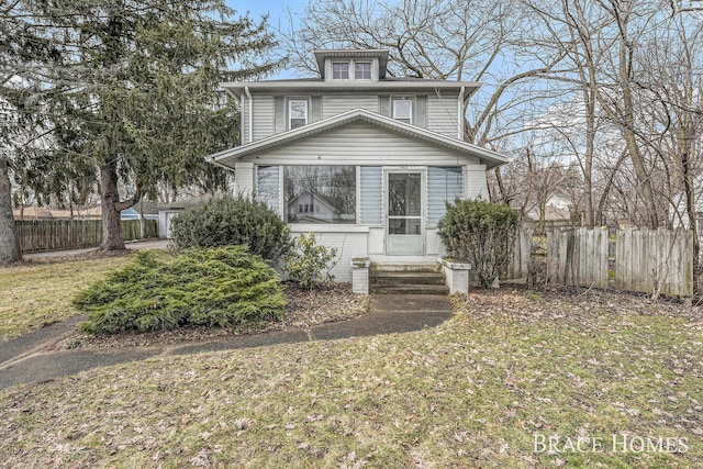 traditional style home featuring entry steps, a front lawn, and fence