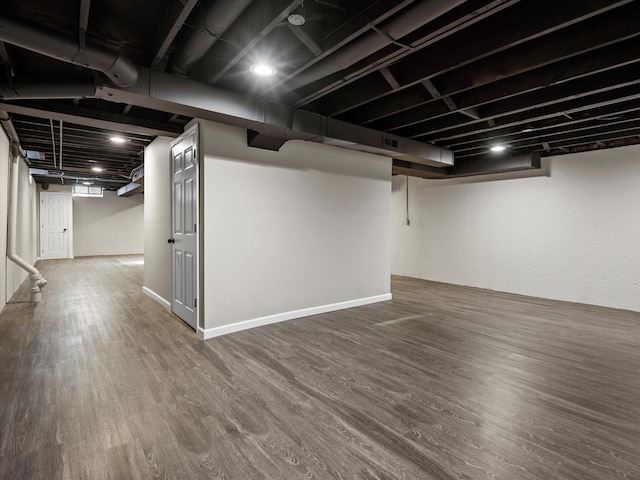 finished below grade area with wood finished floors, visible vents, and baseboards