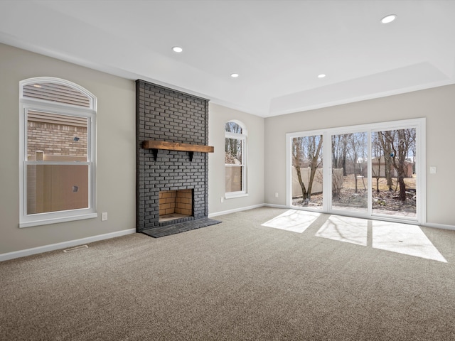 unfurnished living room featuring carpet, a fireplace, and baseboards