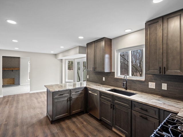 kitchen with dishwasher, dark wood-style flooring, a peninsula, dark brown cabinets, and a sink