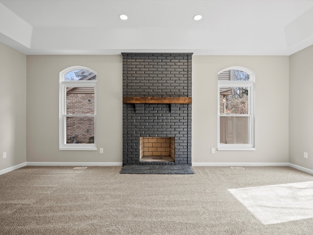 unfurnished living room with carpet floors, recessed lighting, a fireplace, and baseboards