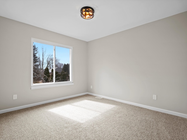 carpeted empty room with visible vents and baseboards