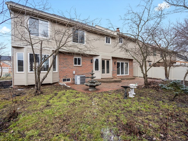 back of house featuring central air condition unit, brick siding, fence, a chimney, and a patio area