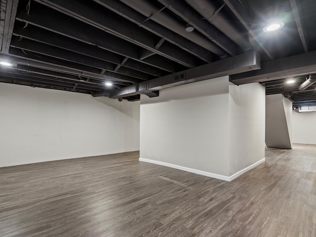 finished basement featuring wood finished floors, visible vents, and baseboards