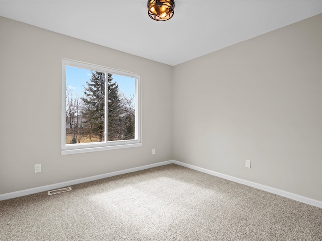 carpeted empty room with visible vents and baseboards