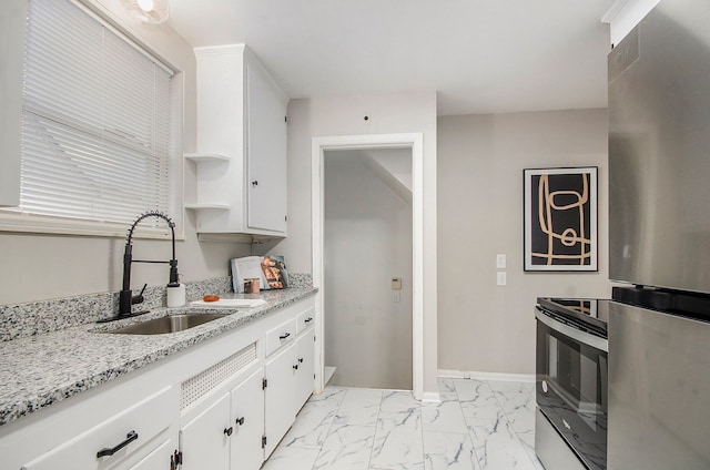 kitchen featuring a sink, white cabinets, marble finish floor, electric stove, and freestanding refrigerator