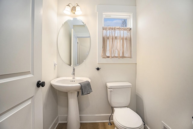 bathroom featuring wood finished floors, toilet, and baseboards