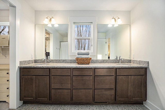 bathroom with double vanity, plenty of natural light, and a sink