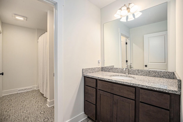 bathroom featuring vanity, visible vents, and baseboards