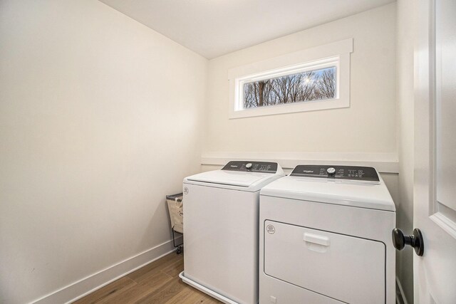 laundry room featuring washing machine and dryer, laundry area, baseboards, and wood finished floors