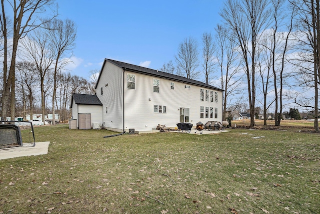 back of house featuring a fire pit, a lawn, and a patio