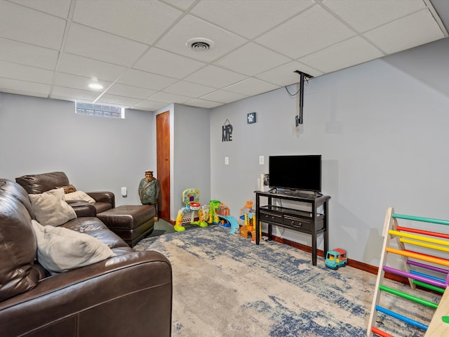 carpeted living area featuring baseboards, visible vents, and a drop ceiling