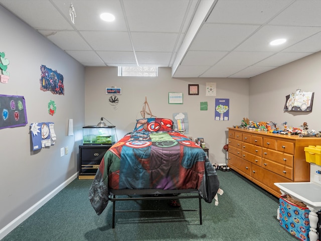 carpeted bedroom with a paneled ceiling and baseboards