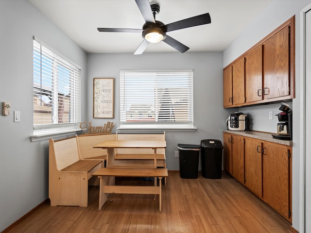 dining space featuring breakfast area, light wood-type flooring, baseboards, and a ceiling fan