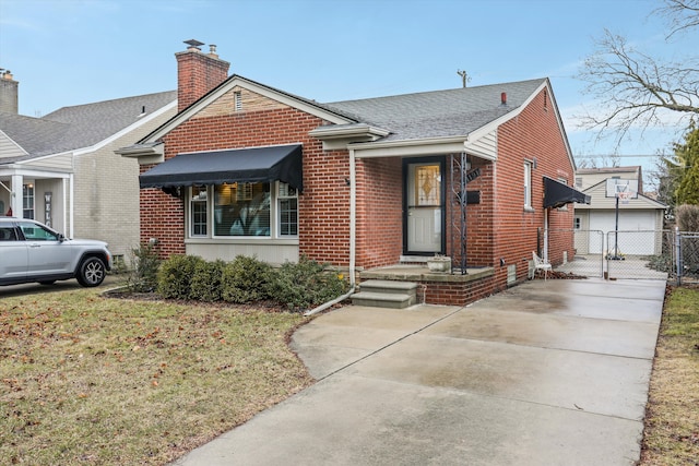 bungalow-style house featuring brick siding, an outdoor structure, fence, roof with shingles, and a gate