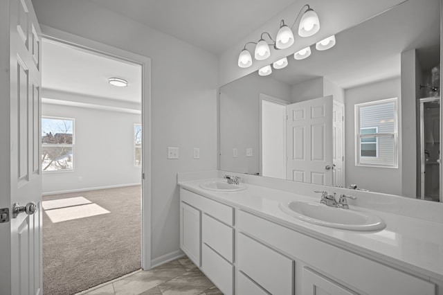 bathroom featuring a sink, baseboards, and double vanity