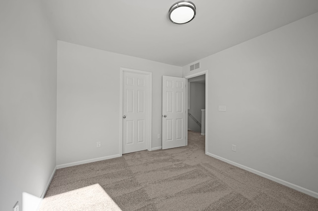 unfurnished bedroom featuring carpet, visible vents, and baseboards