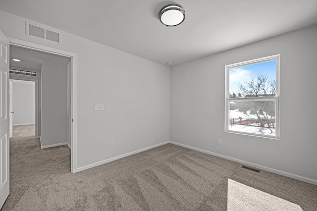 carpeted empty room with visible vents and baseboards