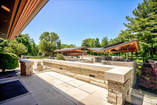 view of patio featuring a gazebo, outdoor dry bar, and area for grilling