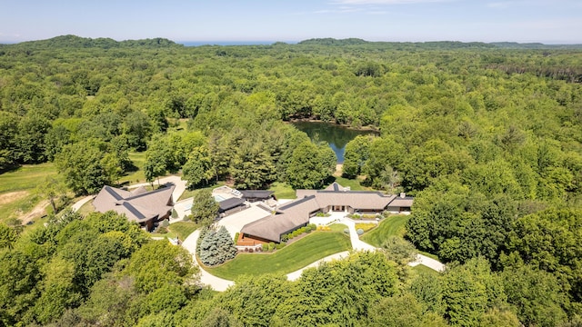 drone / aerial view featuring a wooded view