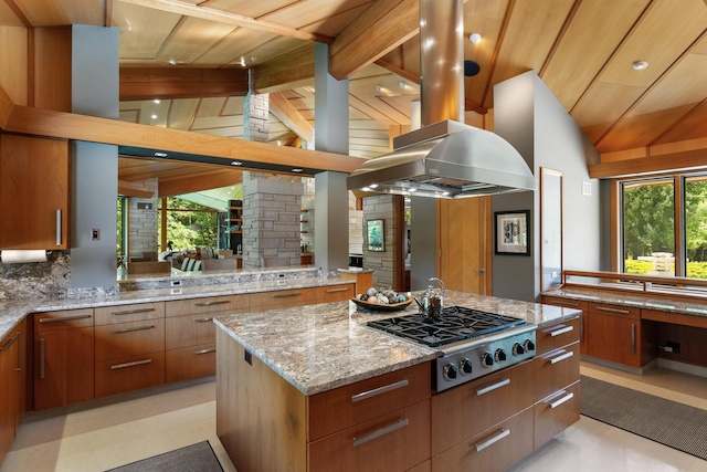 kitchen featuring vaulted ceiling with beams, a center island, stainless steel gas cooktop, and backsplash