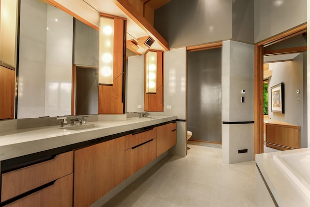 bathroom with visible vents, a sink, toilet, and double vanity