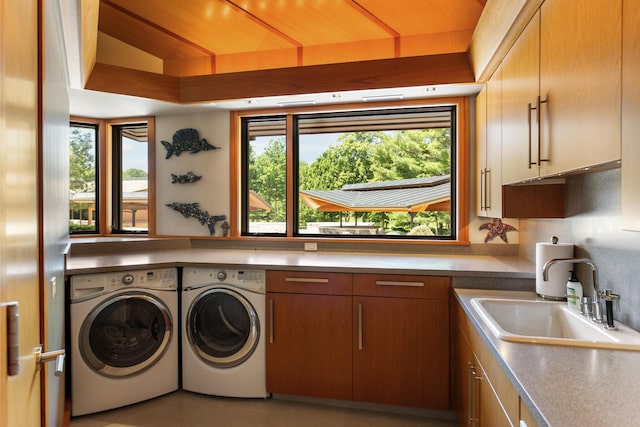 laundry area featuring cabinet space, a sink, and washing machine and clothes dryer