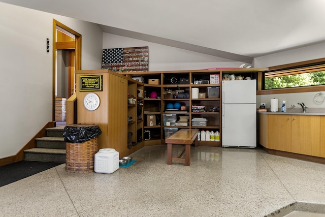 interior space with stairway, a sink, and freestanding refrigerator