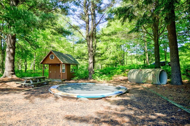 view of yard featuring an outbuilding and a trampoline